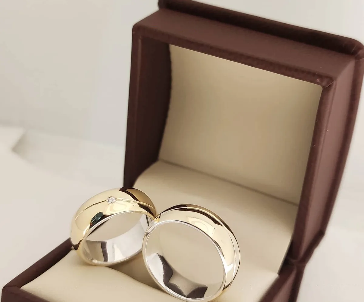Par de argollas de matrimonio en dos tonos con acabado pulido, dentro de su estuche